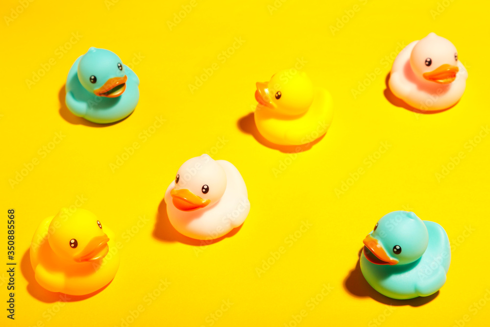 Collection of colorful rubber ducks on a yellow background Collection of colorful rubber ducks on a yellow background