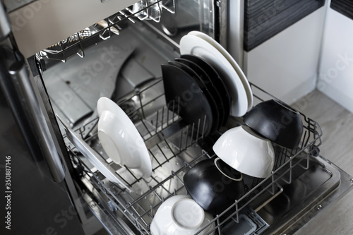 Loading dirty dishes in the dishwasher close up. a