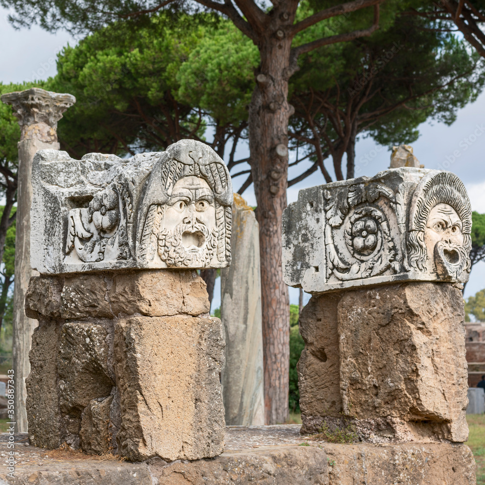 theater stone masks on pedestals in the alley of the ancient Italian city Antica Ostia. Archeology. Excavations