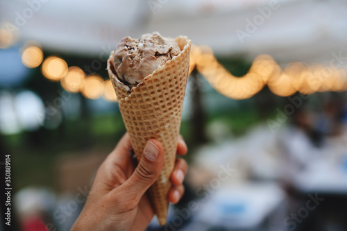 Girl holds in her hand chocolate ice cream, close-up. Cropped image, lifestile © EkaterinaKiseleva