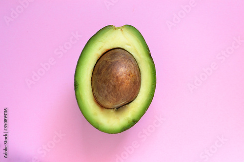 Cut avocado. Avocado on a pastel pink background. Free space for text. Top view. Flat lay. Minimalism and food.