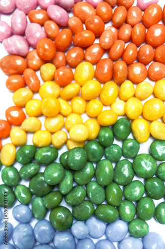 Abstract background filled with assorted bean candies making a rainbow