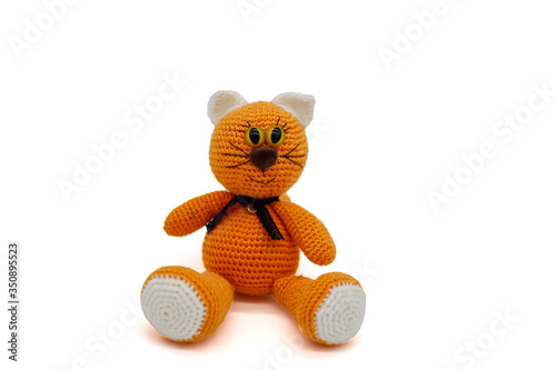 Knitted toy red cat on a white background
