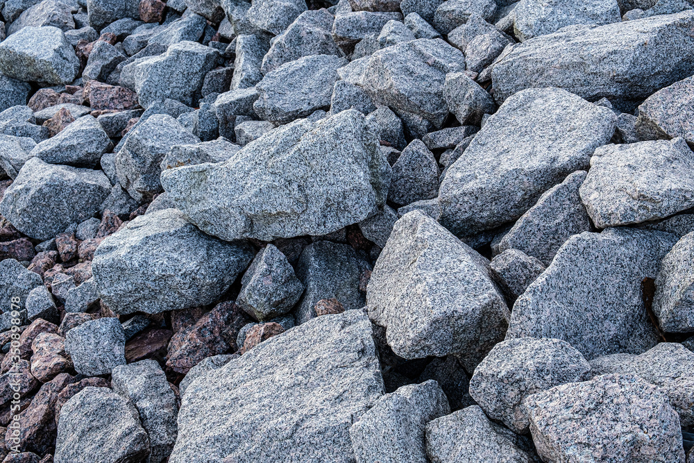 Granite quarry. The texture of granite stone, boulders scattered around.
