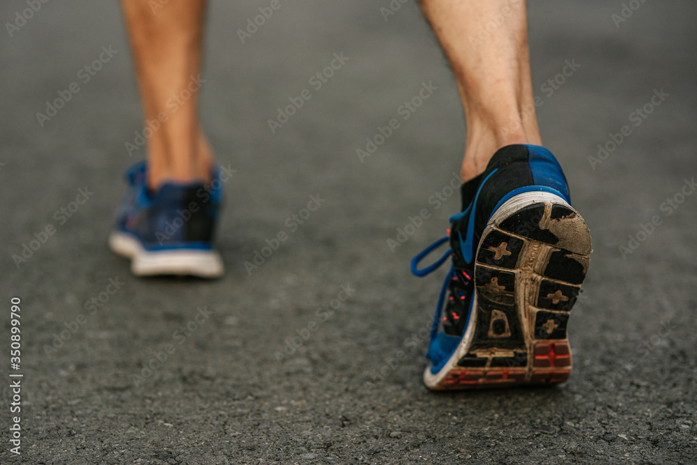 Runner man feet running on road closeup on shoe. Sports healthy lifestyle concept.