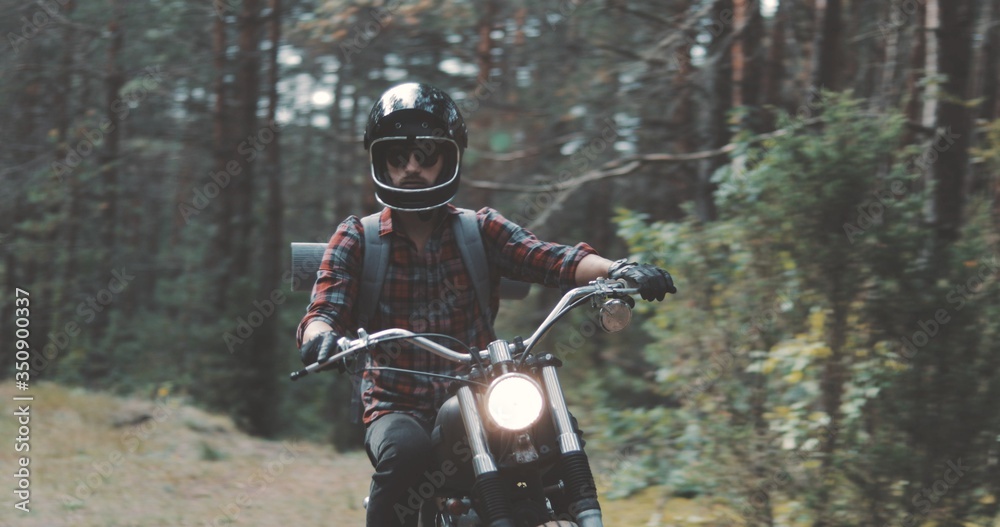 Young rider driving motorcycle on forest road Young rider driving motorcycle on forest road
