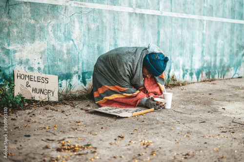 Beggars sitting on the street with homeless messages please help.