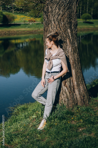 young teenager girl stands in a park by the lake © yana_novak22