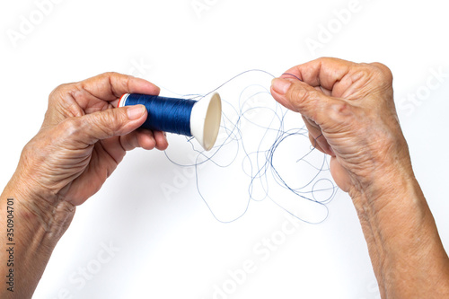 Senior woman hands spinning to dark blue thread roll on isolated white background, Skeins of thread, Close up and macro shot Asian body part, Hobby, About Tailor Processing concept