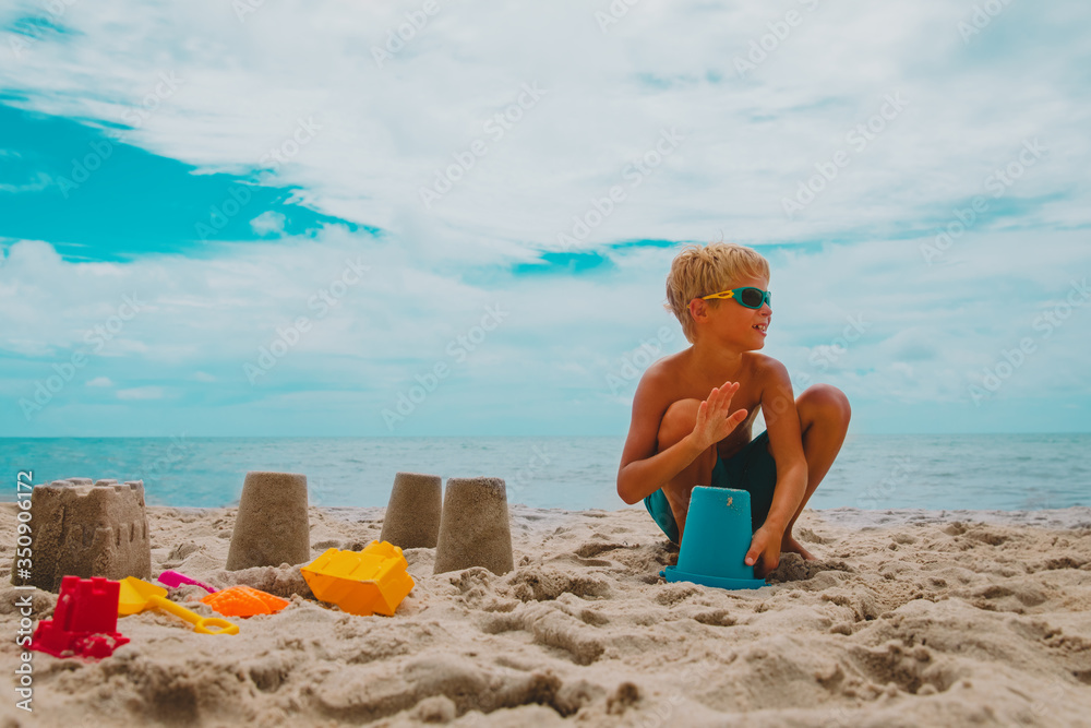 happy kid building from sand on tropical beach happy kid building from sand on tropical beach