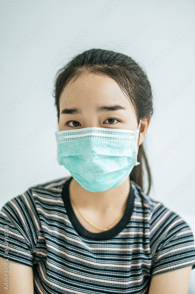 A woman wearing a striped shirt wearing a mask. A woman wearing a striped shirt wearing a mask.