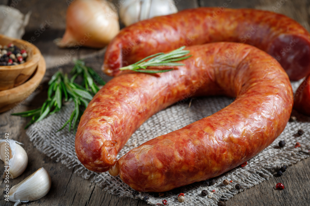 Smoked sausage on a wooden table. Rustic style. Smoked sausage on a wooden table. Rustic style.