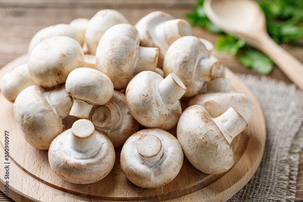 Fresh mushrooms champignon mushrooms on a wooden table. Fresh mushrooms champignon mushrooms on a wooden table.