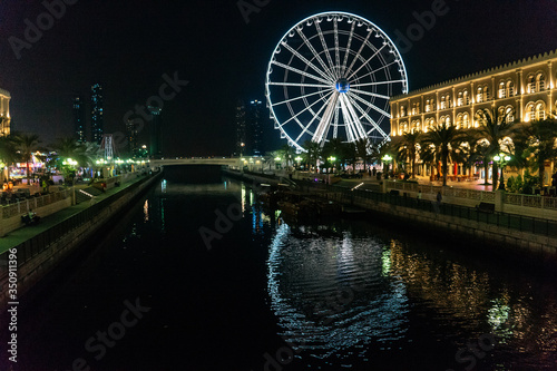 Eye of the Emirates. Illuminated Ferris wheel at night in al qasba in Sharjah | UNITED ARAB EMIRATES, SHARJAH - 17 OCTOBER 2017.