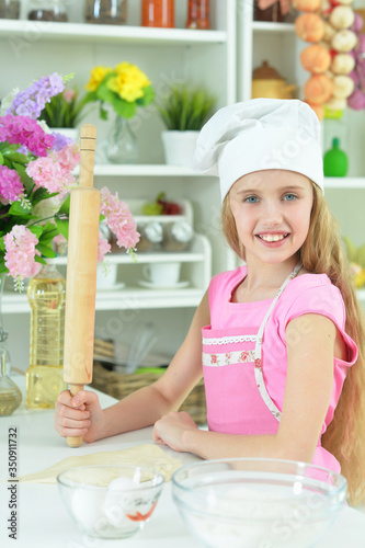 Beautiful girl baking and posing in the kitchen at home