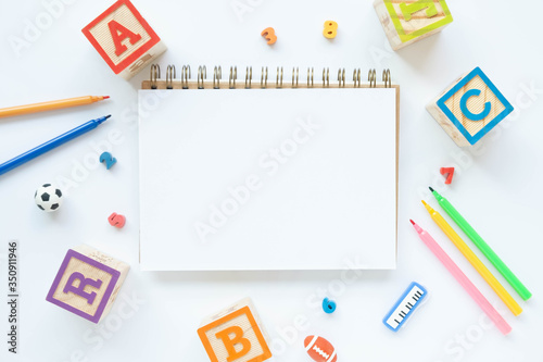 Flat lay with copy space school desktop workspace with colorful Stationary .pen,pencil,glasses,document,wood alphabet and notebook.For Back to Schook,Home School Concept.