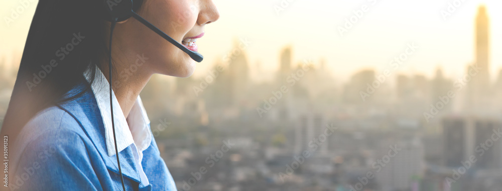 Attractive business woman Asian in suits and headsets are smiling while working with computer at office. Customer service assistant working in office