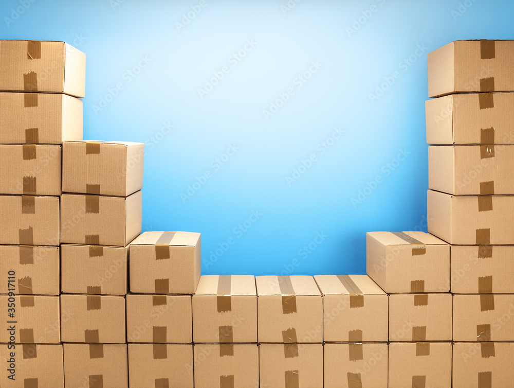 Cardboard boxes frame for delivery or moving. Stack of boxes and blue background. Copy space for text Cardboard boxes frame for delivery or moving. Stack of boxes and blue background. Copy space for text