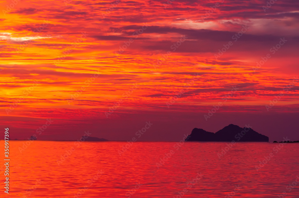 Fiery red sunset overlooking a small island