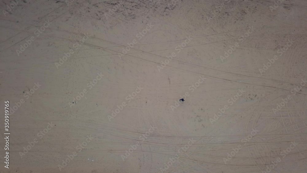 A man walks along a sandy field, leaving footprints in the sand. View from above. A man walks along a sandy field, leaving footprints in the sand. View from above.