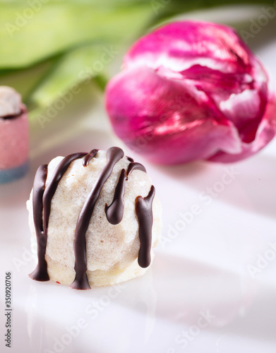 Chocolate candy without sugar and purple tulip on the background. Raw vegan chocolate candies. Lactose free candies. Gluten free candies. Without artificial dyes chocolate. photo