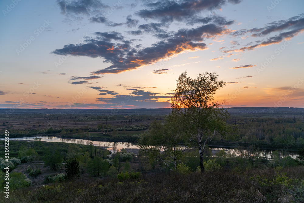 Spring sunset on a hillside overlooking the river