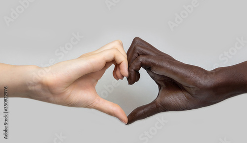 Tableau sur toile Black and white heart-shaped hands on a grey isolated background