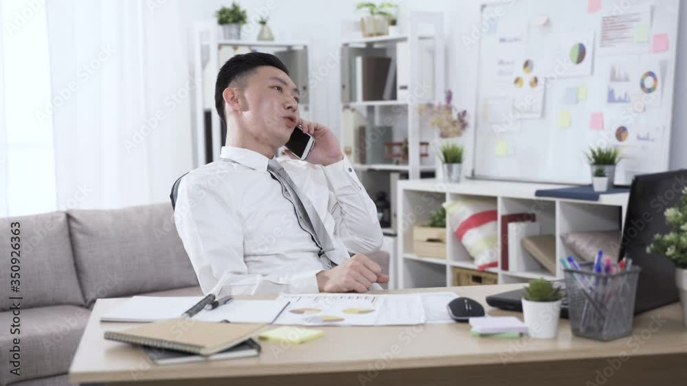 portrait asian businessman sitting in his personal office is speaking on phone with hand gestures. technology and communication concept. portrait asian businessman sitting in his personal office is speaking on phone with hand gestures. technology and communication concept.