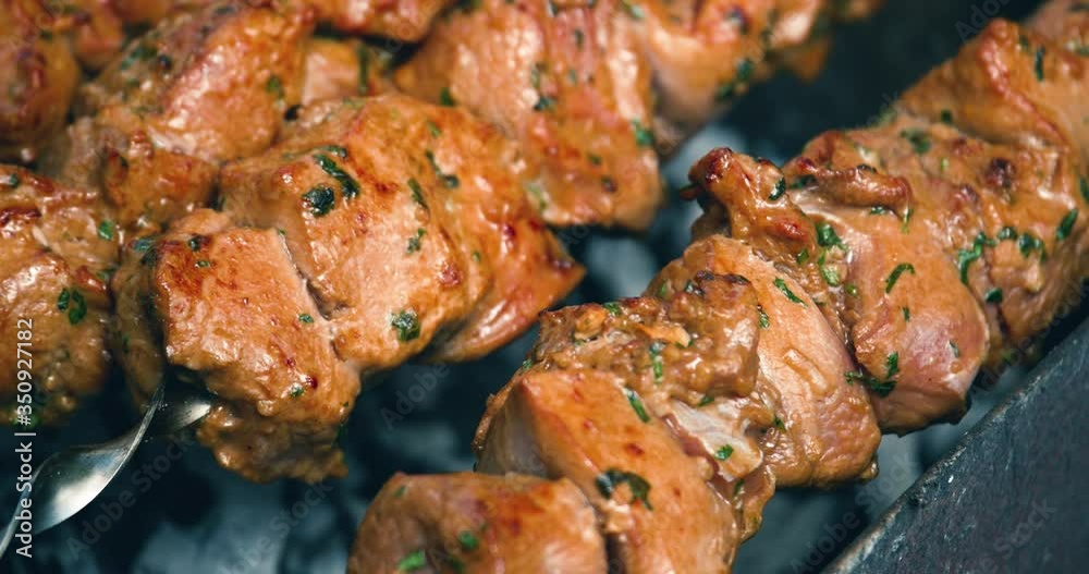 Rotating the skewers. Shish kebab. Pork or lamb meat pieces being fried on a charcoal grill. Frying grilled pieces of meat during the rest. Close up, 4k Rotating the skewers. Shish kebab. Pork or lamb meat pieces being fried on a charcoal grill. Frying grilled pieces of meat during the rest. Close up, 4k