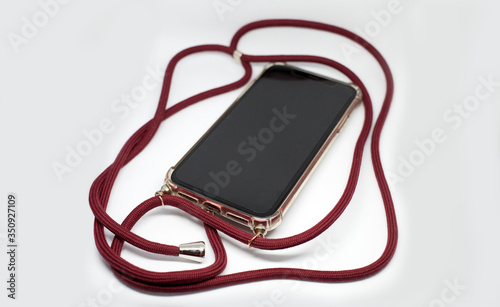 Smartphone in transparent case crossbody with red long textile strap, comfortable usage of mobile phone protective accessory