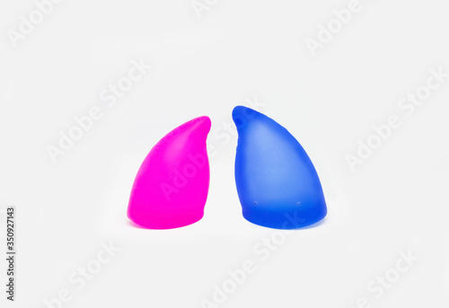 Two colorful, pink and blue sizes of menstural cups from medical high quality silicone, 20 and 30 ml capacity, for safe menstual female period, ecological, zero waste device at isolated background