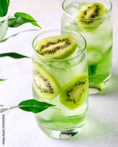 Glass of Refreshing Tropical Kiwi Lemonade With Ice on Light Gray Background Tasty Summer Beverage Healthy Detox Diet Drink photo