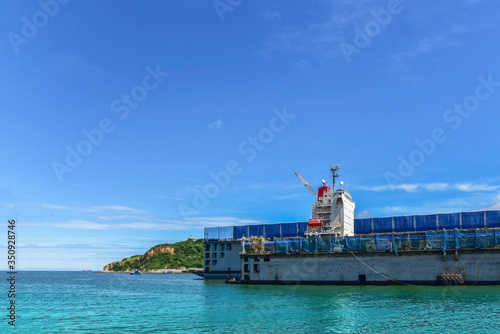 Shipyard accommodation bridge deck of Cargo ship during repair in floating dry dock with safety life boat exhaust pipe gas on the blue-sky blue sea Thailand