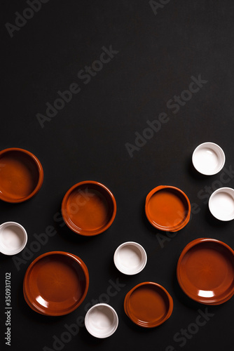 Empty ceramic trays top view on black background