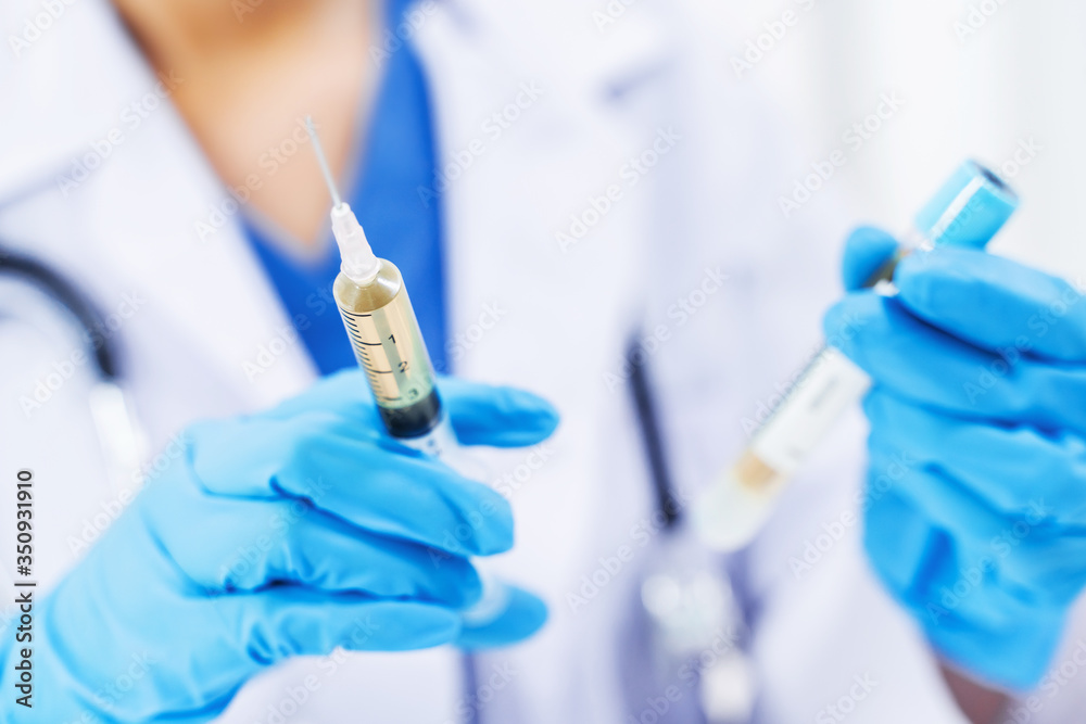 Doctor holding medical injection syringe in hospital. Doctor holding medical injection syringe in hospital.