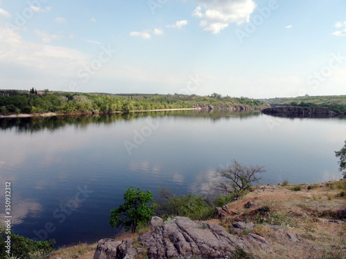 Unique landscape of the water mirror of the calm Dnieper, which carries its waters between the islands of Khortytsia and Baida against the spring blue sky.