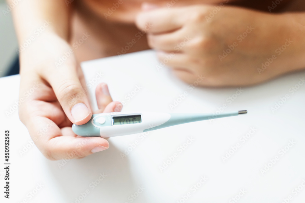 close up of woman checking thermometer and measure body temperature. close up of woman checking thermometer and measure body temperature.