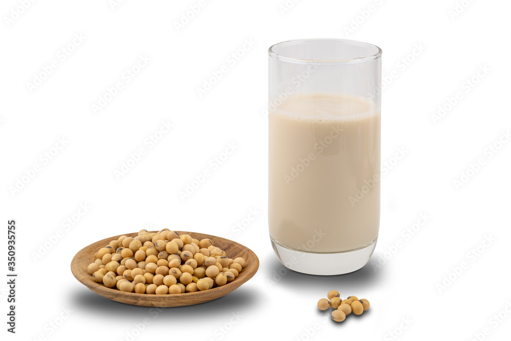 Soymilk in a glass and soy beans in a wooden plate on white background with clipping path. Soymilk in a glass and soy beans in a wooden plate on white background with clipping path.