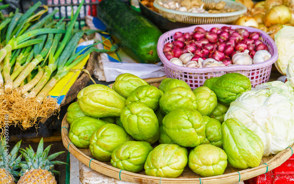 Asian street market selling chayote garlic cabbage and zucchini reflex