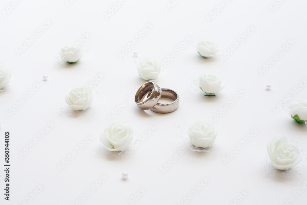 Wedding rings close-up on a white background top view. The concept of wedding cards. Wedding rings close-up on a white background top view. The concept of wedding cards.