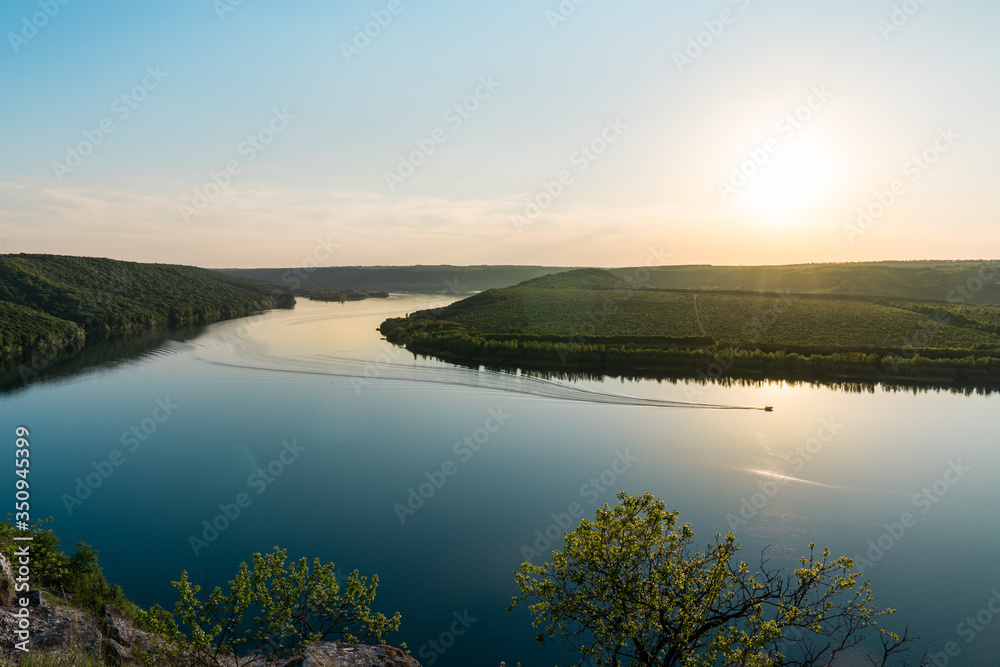 Panorama of a winding river with a floats motor boat