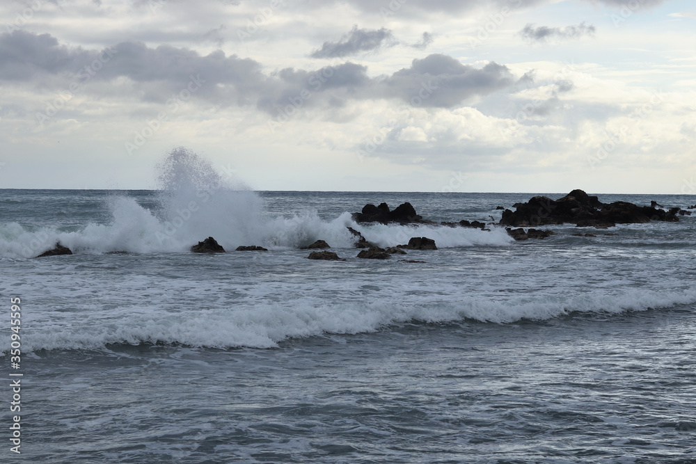 Stormy sea during a storm near Paphos, Cyprus. The waves crash against the rocks that protrude from the sea. The droplets fly up to two meters high. Abstract. The power of the ocean