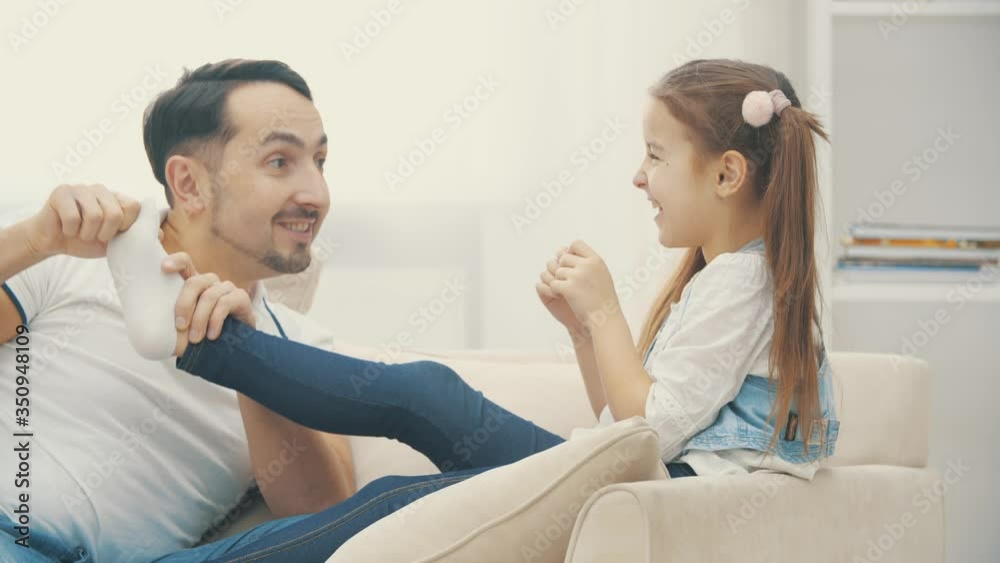 4k video where father playing wih daughter's feet. 4k video where father playing wih daughter's feet.