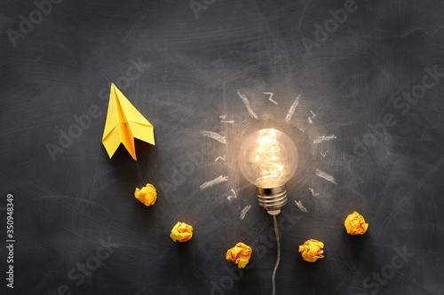 Education concept image. Creative idea and innovation. Light bulb as metaphor over blackboard photo