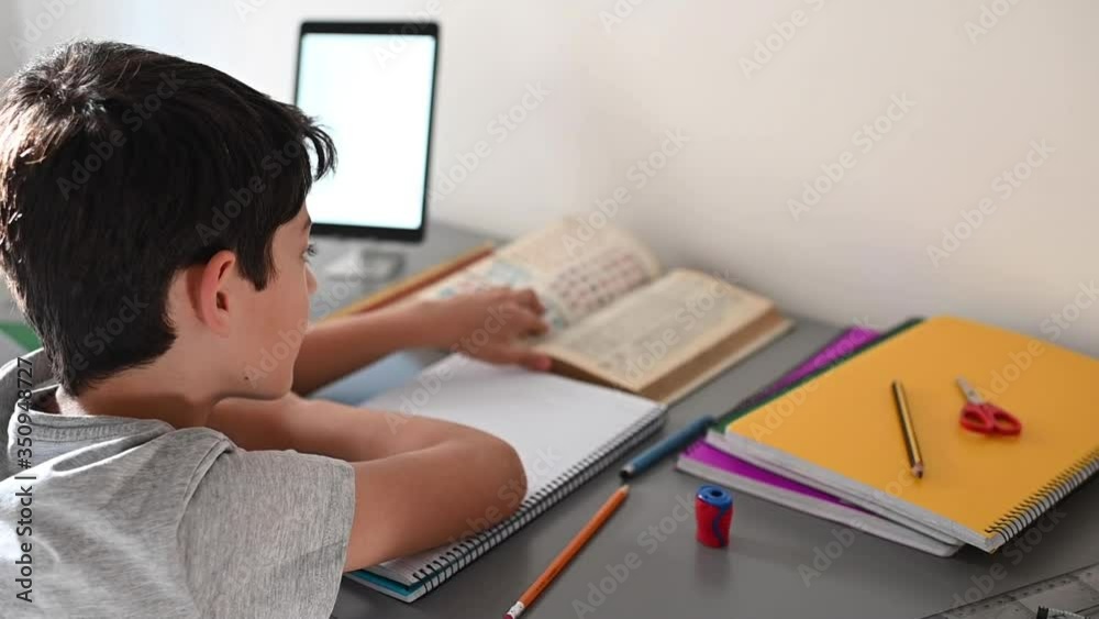 Stress kid doing homework.Boy at study table doing homework with stress action.Lazy boy doing homework with stressed face. Stress kid doing homework.Boy at study table doing homework with stress action.Lazy boy doing homework with stressed face.