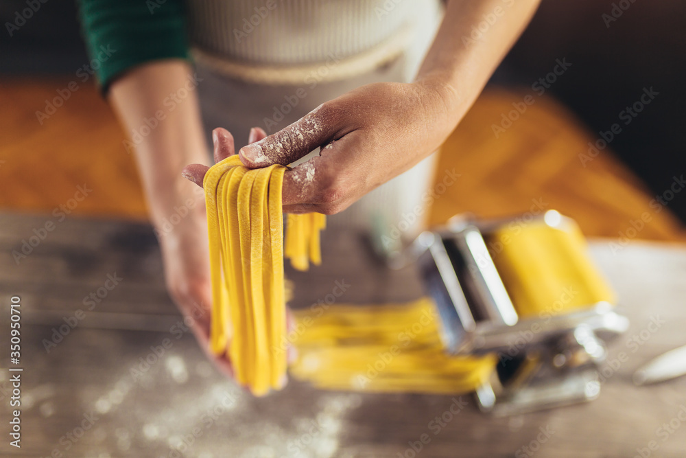 Closeup of process of making cooking homemade pasta. Woman make fresh italian traditional pasta. - obrazy, fototapety, plakaty 