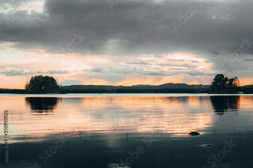 Dramatic sky over lake Siljan with two small islets in frame in Sweden, Dalarna, Orsa  photo