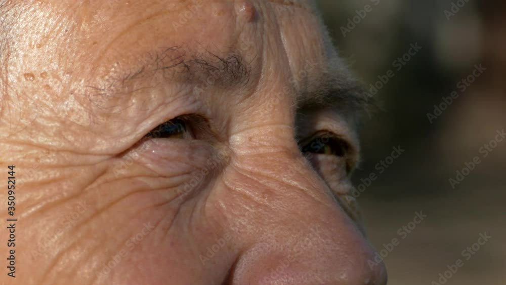 The face and eyes of an old man. Large wrinkles on the face of an old woman. Face close up. A senior citizen looks into the distance. The face and eyes of an old man. Large wrinkles on the face of an old woman. Face close up. A senior citizen looks into the distance.