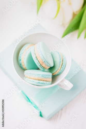 Mint or tiffany color macaron or macaroon dessert with vanilla cream in glass. Paste photo, copy space