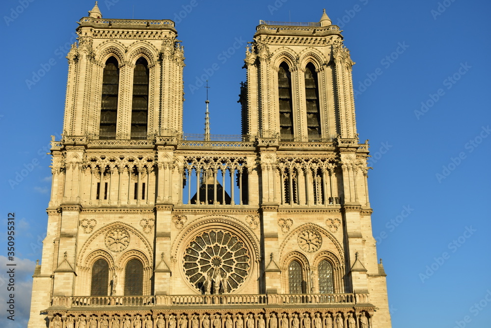 Notre-Dame de Paris Cathedral facade closeup at sunset with blue sky. Paris, France.